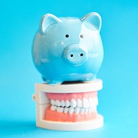 Piggy bank sitting on model teeth