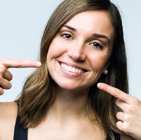 Woman pointing to a healthy smile.