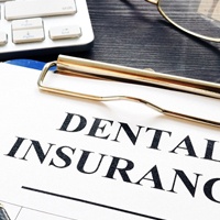 Dental insurance form and pen on a desk.