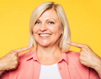 woman pointing at her dentures in San Antonio. 