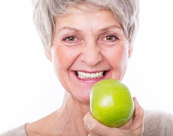 older woman holding an apple