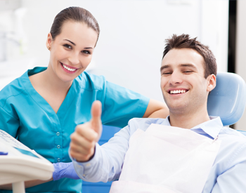 Man in dental chair giving thumbs up