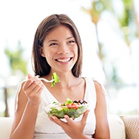 Woman eating a healthy salad and smiling